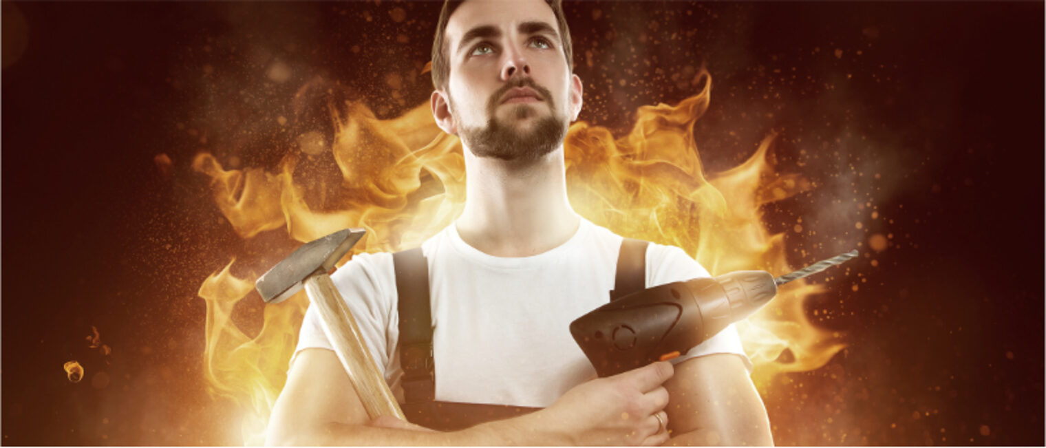 Ein junger Mann, mit verschränkten Armen, mit einem Hammer und einer Bohrmaschine in der Hand. Hinter ihm Flammen.