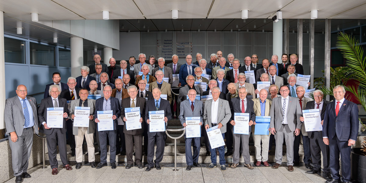 Zu einem Gruppenbild stellten sich die Goldenen Meister 2019 mit dem Kreishandwerksmeister Norbert Menges (links) sowie Präsident Alois Jöst (rechts), Vizepräsident Klaus Hofmann (4. von rechts), Ehrenvizepräsident Gerhard Höfler (3. von rechts), Ehrenkreishandwerksmeisterin Margot Preisz (5. von links), Hauptgeschäftsführer Jens Brandt (letzte Reihe, 6. von rechts), Obermeister der Innung für Elektro- und Informationstechnik Heidelberg, Martin Illing (letzte Reihe, 4. von rechts), als Vertreter der Metall-Innung Sinsheim, Thomas Nerpel (2. Reihe, links) und Geschäftsbereichsleiter Meisterprüfung der Handwerkskammer Alexander Dirks (letzte Reihe, 2. von rechts) auf. Goldene Meister 2019 Heidelberg