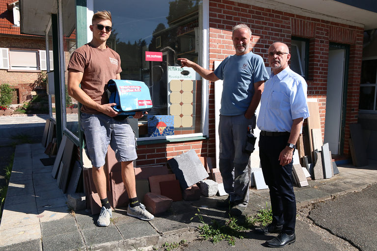 Sohn Luis Miksch und Hartmut Miksch im eigenen Fliesenlegermeisterbetrieb nahmen freudig den Werkzeugkoffer aus den Händen von Detlev Michalke, Leiter der Pressestelle der Handwerkskammer, entgegen