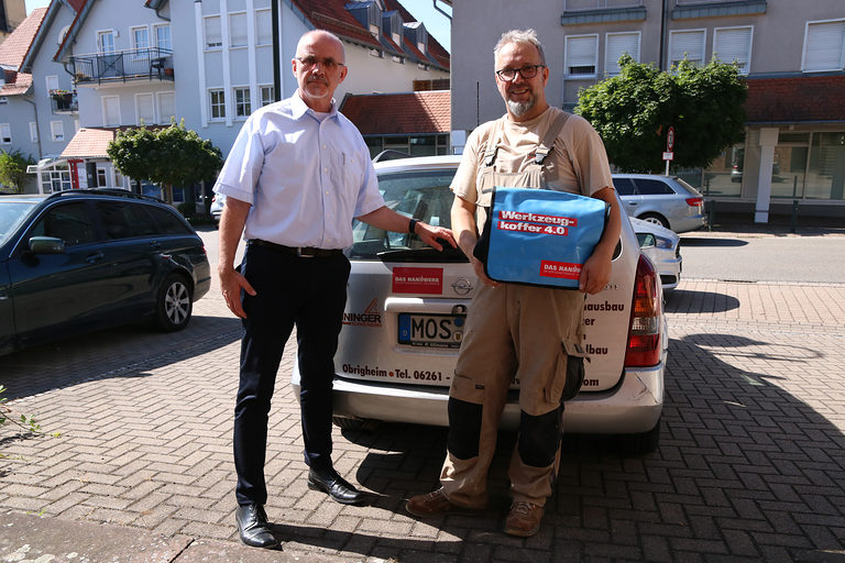 Detlev Michalke, Leiter der Pressestelle der Handwerkskammer, überreichte das Präsent an den Inhaber der eigenen Sreinerei Steffen Hinninger