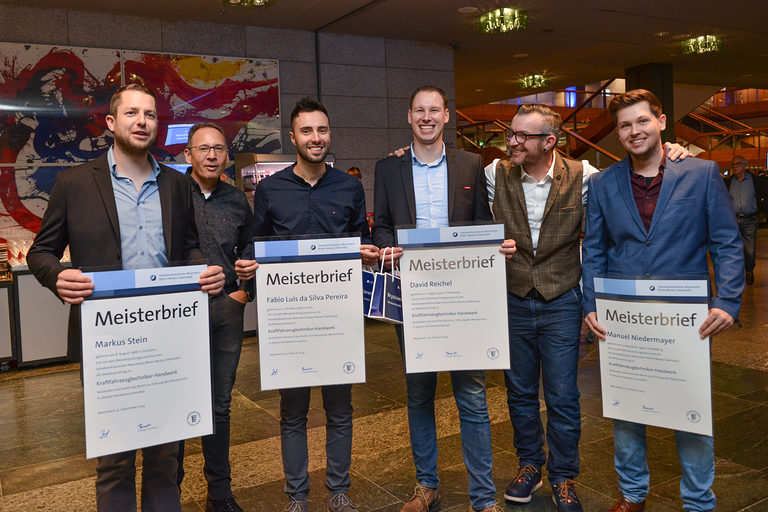 Vier Meister mit ihrem Meisterbrief in der Hand im Foyer des Rosengartens Mannheim auf der Meisterfeier 2019.