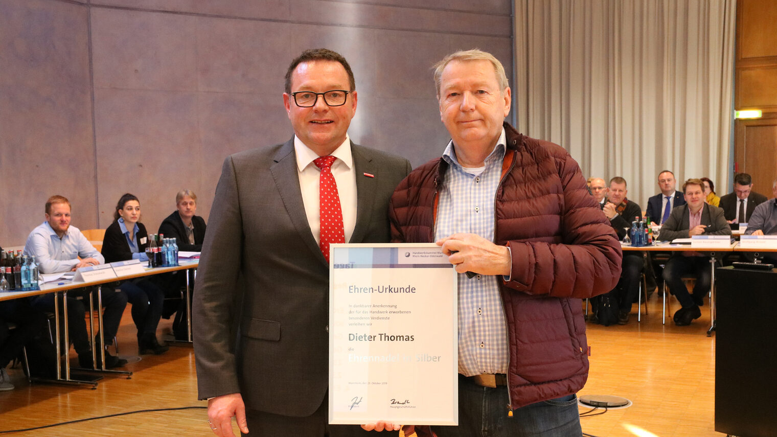 © Handwerkskammer | Kammerpräsident Klaus Hofmann (links) ehrt Dieter Thomas (rechts) mit der Silbernen Ehrennadel.