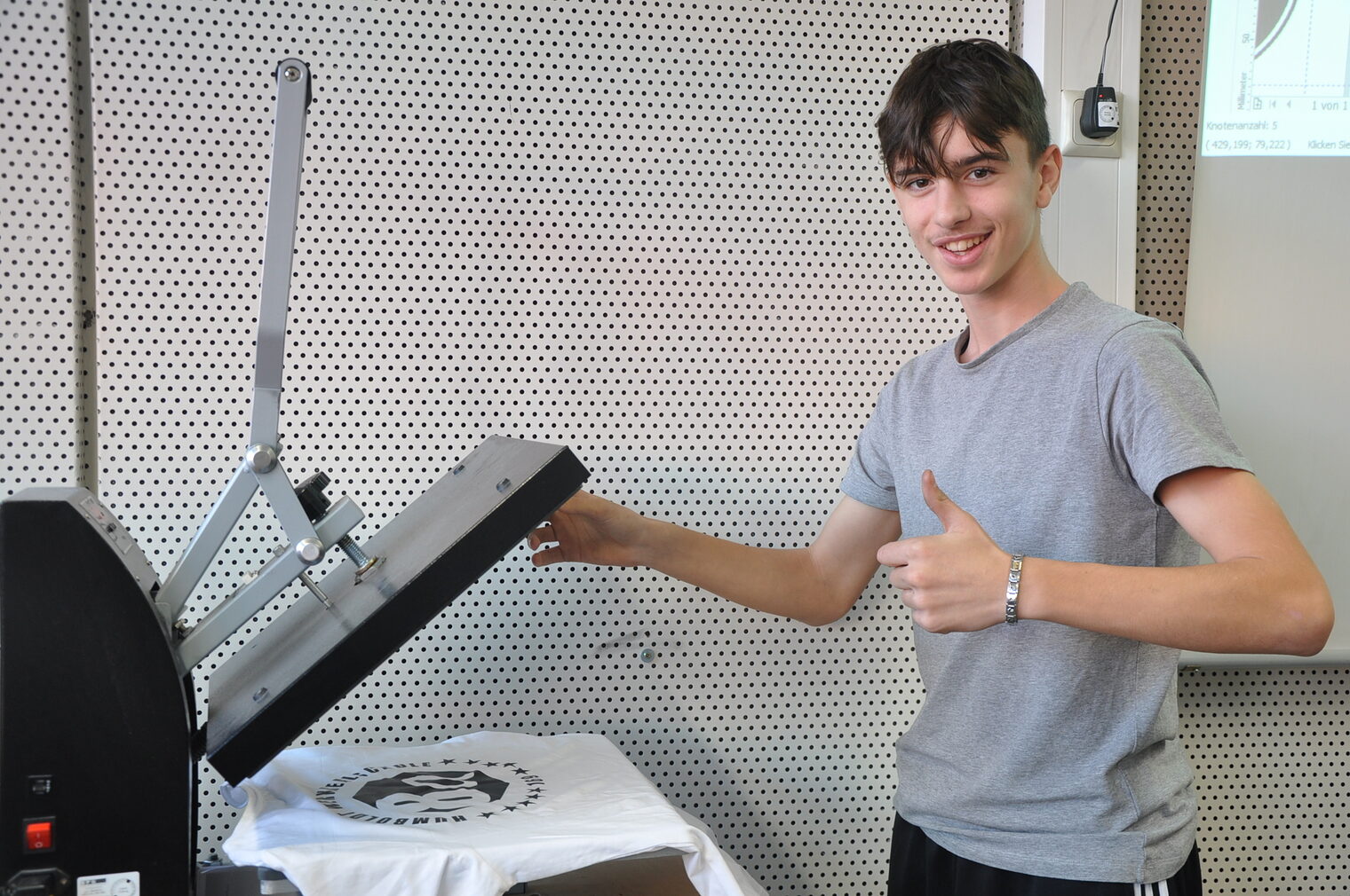 Schüler an einer Heißpresse beim T-Shirt-Druck im Rahmen der Werkstatt-Tage der Bildungsakademie Mannheim. 