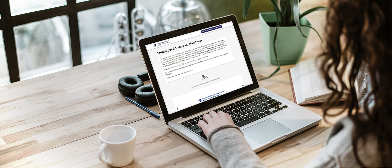 Azubi Speed Dating Handwerk: Junger Mensch am Laptop, der zusammen mit einer Kaffeetasse auf dem Tisch platziert ist.