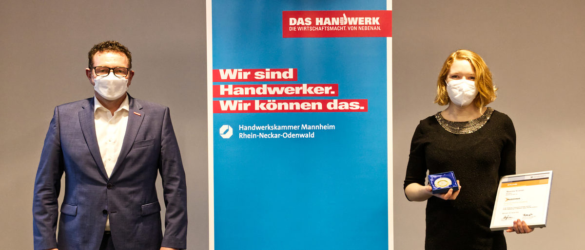 Frauenpersönlichkeit Maxime Krämer Aus der Hand von Kammerpräsident Klaus Hofmann erhielt Schreinermeisterin Maxime Krämer aus Heidelberg die Urkunde samt Medaille im Vorstandszimmer der Kammer überreicht.