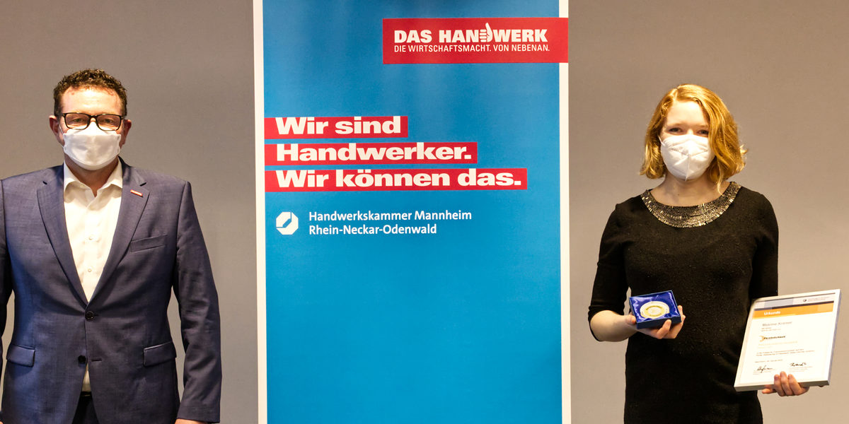 Frauenpersönlichkeit Maxime Krämer Aus der Hand von Kammerpräsident Klaus Hofmann erhielt Schreinermeisterin Maxime Krämer aus Heidelberg die Urkunde samt Medaille im Vorstandszimmer der Kammer überreicht.