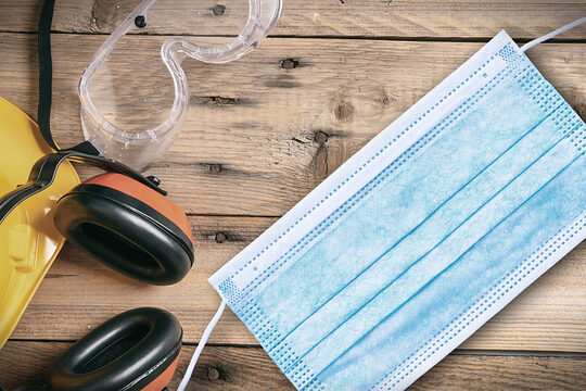 Arbeitsschutz und Gesundheit, gelber Helm, Ohrenschutz und Mundschutz