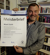 Meisterprüfling mit Meisterbrief in der Hand