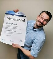 Person mit Meisterbrief in der Hand