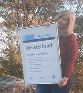 Person mit Meisterbrief in der Hand