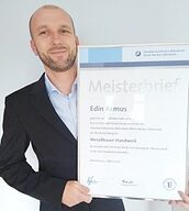 Person mit Meisterbrief in der Hand