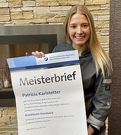 Person mit Meisterbrief in der Hand