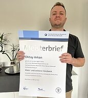 Person mit Meisterbrief in der Hand