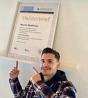 Person mit Meisterbrief in der Hand