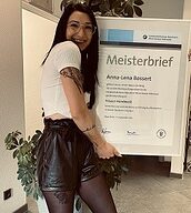 Person mit Meisterbrief in der Hand