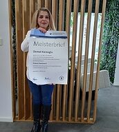 Person mit Meisterbrief in der Hand