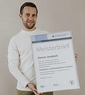 Person mit Meisterbrief in der Hand