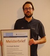 Person mit Meisterbrief in der Hand