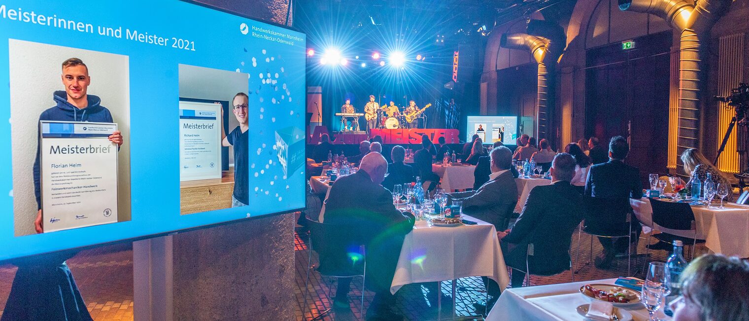 Meisterfeier 2021 - Bildschirm mit Übertragung des Live-Streams und Saalgäste