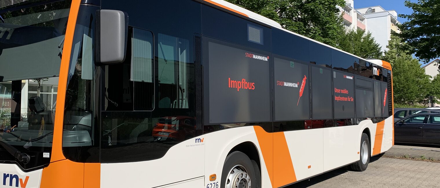 Bus in den Farben orange und weiß, Logo rnv und Aufschrift Impfbus auf den Fenstern 