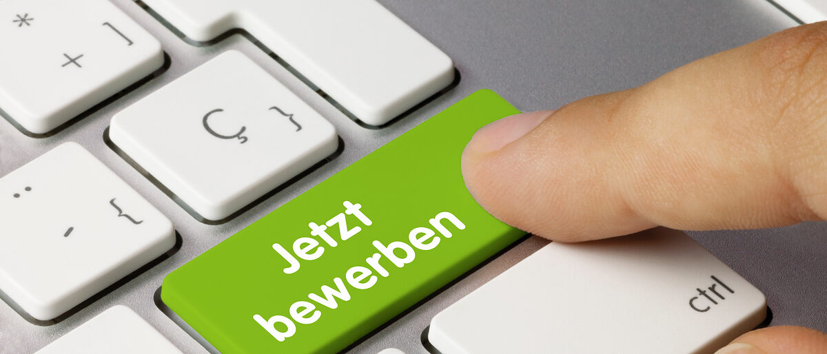 Jetzt bewerben Tastatur. Finger Tastatur auf der eine Taste mit "Jetzt bewerben" beschriftet ist.