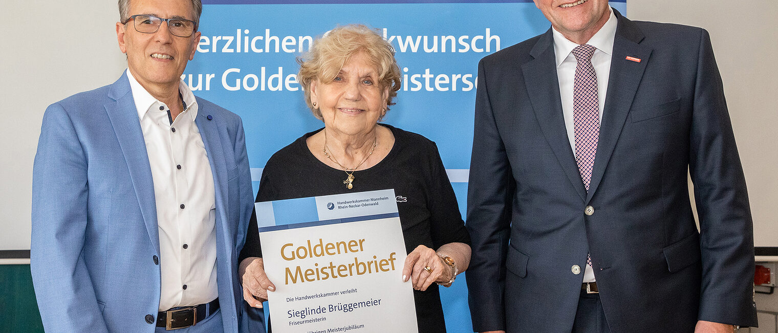 Goldene Meisterfeier 2022 - Friseurmeisterin Sieglinde Br&uuml;ggemeier mit Kammerpr&auml;sident Klaus Hofmann und dem Obermeister der Friseur und Kosmetik Innung Mannheim Salvatore Jaci