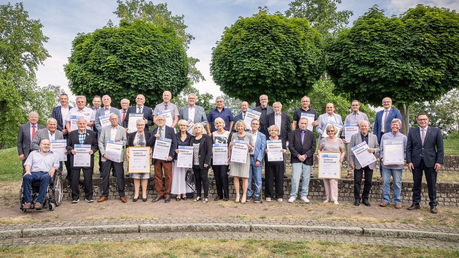 Goldene Meister mit ihrem Goldenen Meisterbrief im Außenbereich der Bildungsakademie