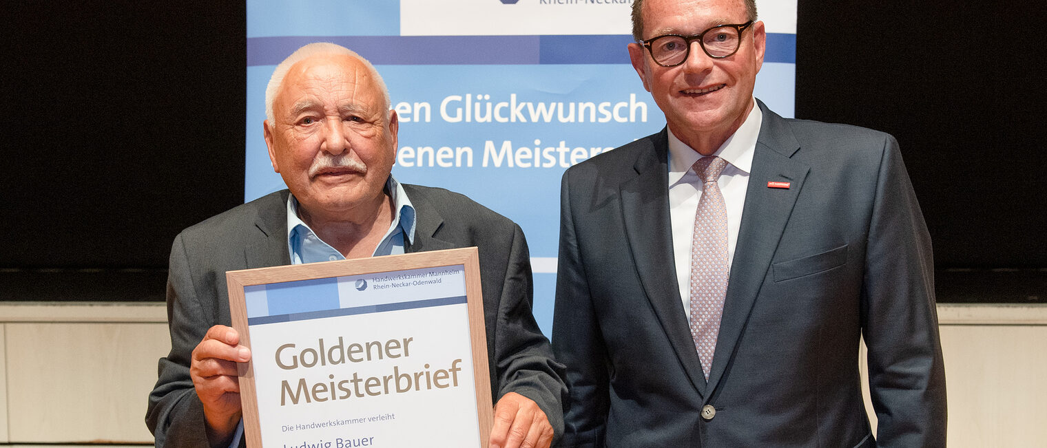 Kammerpräsident Klaus Hofmann überreicht Bäckermeister Ludwig Bauer auf der Goldene Meisterfeier in Wiesloch 2022 seinen Goldenen Meisterbrief