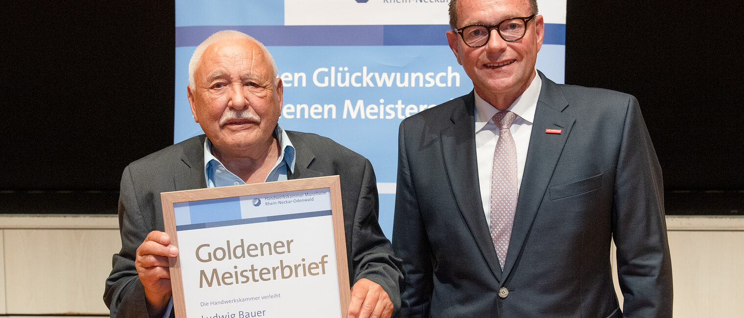 Kammerpr&auml;sident Klaus Hofmann &uuml;berreicht B&auml;ckermeister Ludwig Bauer auf der Goldene Meisterfeier in Wiesloch 2022 seinen Goldenen Meisterbrief