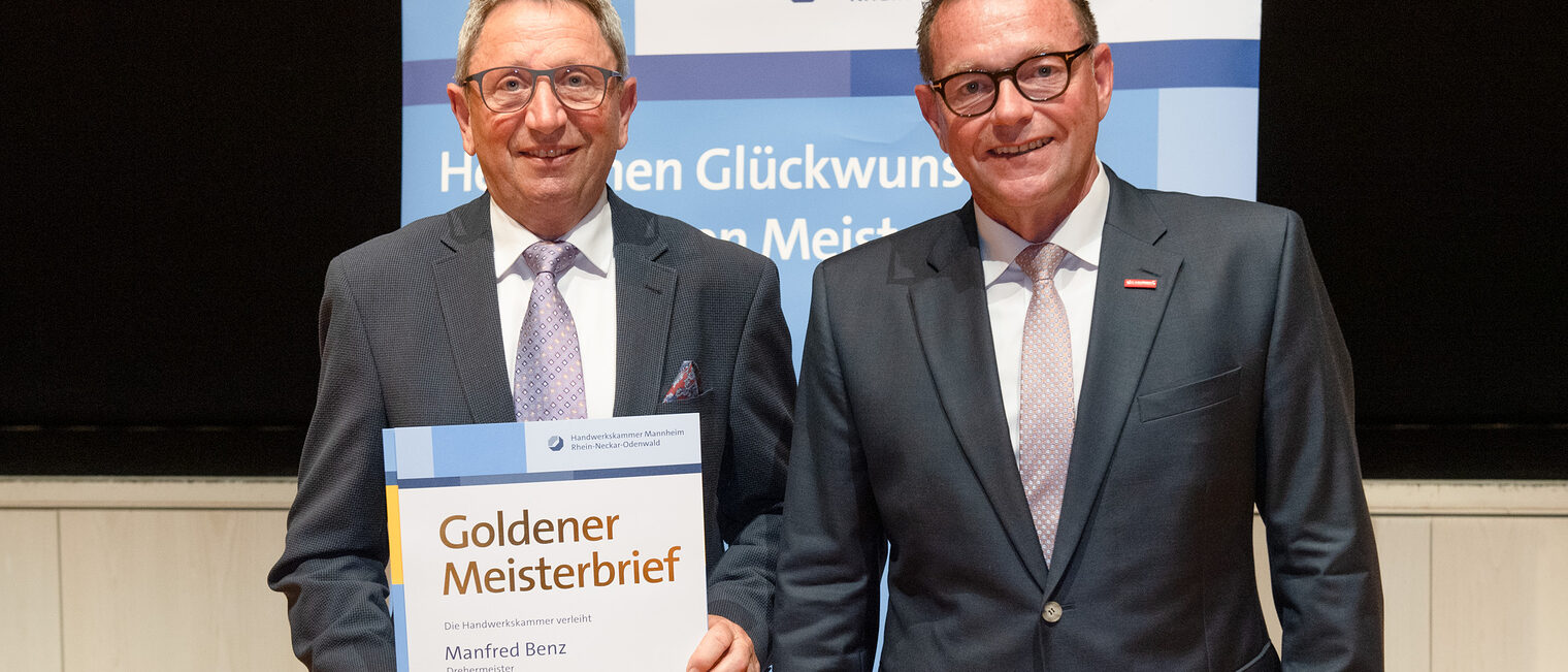 Kammerpr&auml;sident Klaus Hofmann &uuml;berreicht Drehermeister Manfred Benz auf der Goldene Meisterfeier in Wiesloch 2022 seinen Goldenen Meisterbrief