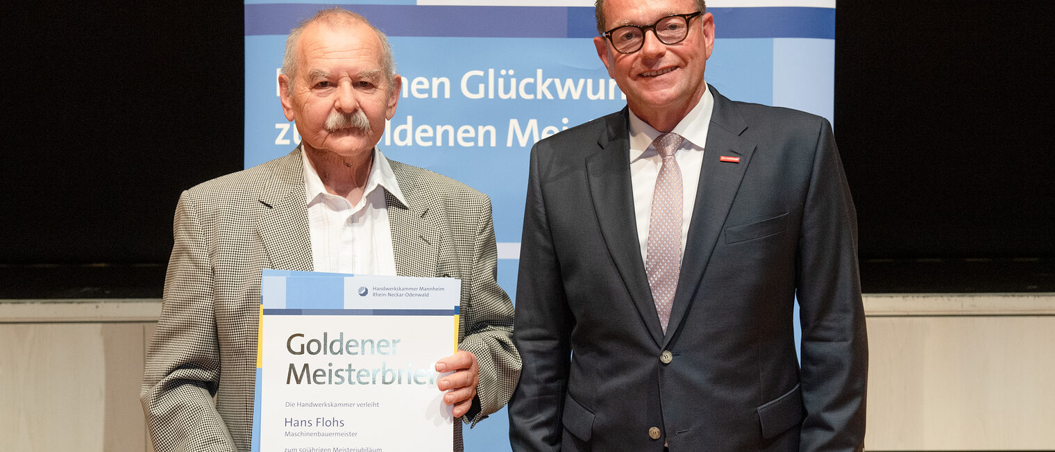 Kammerpr&auml;sident Klaus Hofmann &uuml;berreicht Maschinenbauermeister Hans Flohs auf der Goldene Meisterfeier in Wiesloch 2022 seinen Goldenen Meisterbrief