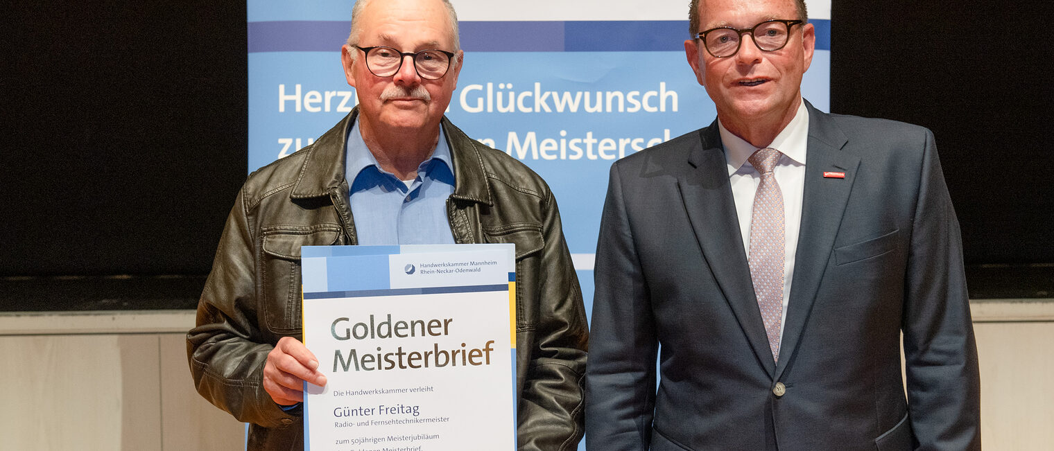 Kammerpr&auml;sident Klaus Hofmann &uuml;berreicht Radio- und Fernsehtechnikermeister G&uuml;nter Freitag auf der Goldene Meisterfeier in Wiesloch 2022 seinen Goldenen Meisterbrief