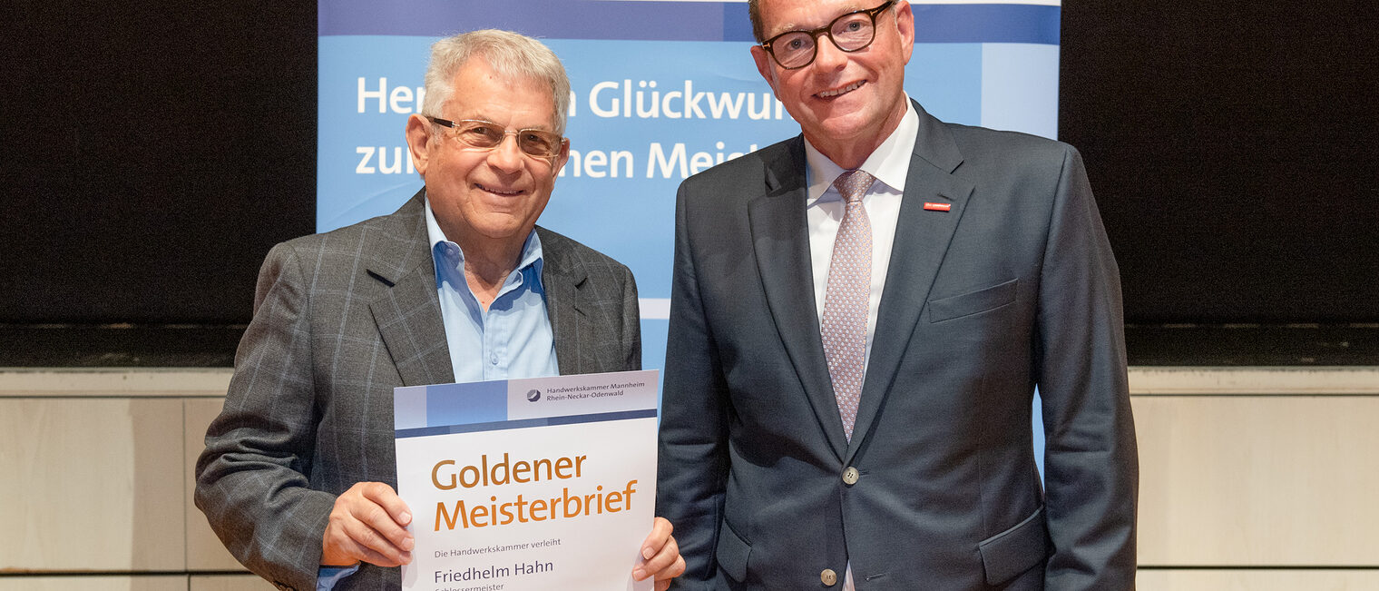 Kammerpr&auml;sident Klaus Hofmann &uuml;berreicht Schlossermeister Friedhelm Hahn auf der Goldene Meisterfeier in Wiesloch 2022 seinen Goldenen Meisterbrief