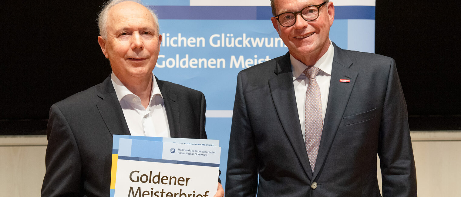 Kammerpräsident Klaus Hofmann überreicht Fleischermeister Wilhelm Jörger auf der Goldene Meisterfeier in Wiesloch 2022 seinen Goldenen Meisterbrief