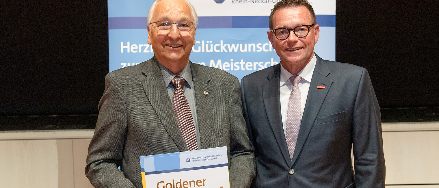 Kammerpräsident Klaus Hofmann überreicht Gas- und Wasserinstallateurmeister Egon Koppert auf der Goldene Meisterfeier in Wiesloch 2022 seinen Goldenen Meisterbrief