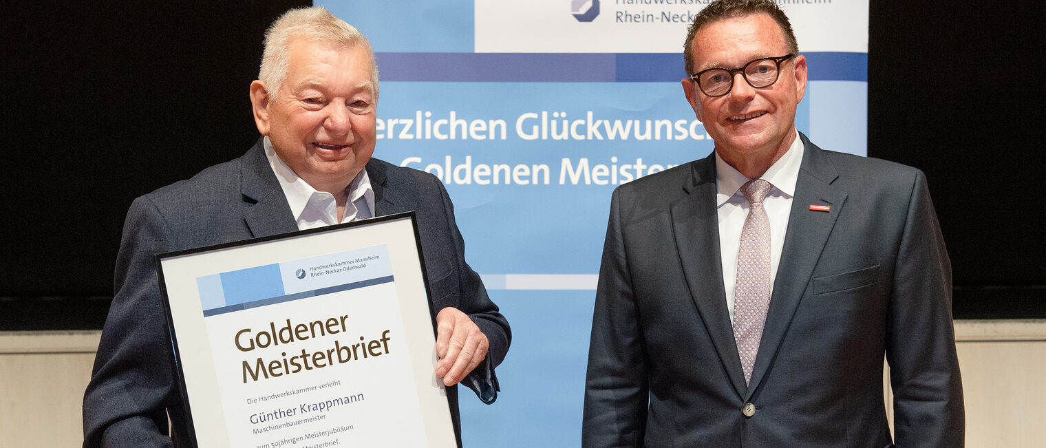 Kammerpr&auml;sident Klaus Hofmann &uuml;berreicht Maschinenbauermeister G&uuml;nther Krappmann auf der Goldene Meisterfeier in Wiesloch 2022 seinen Goldenen Meisterbrief