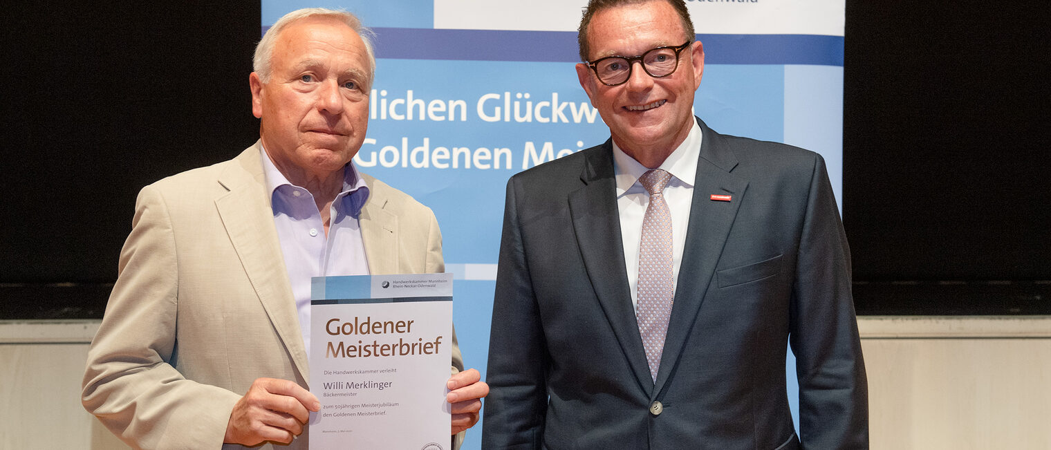 Kammerpr&auml;sident Klaus Hofmann &uuml;berreicht B&auml;ckermeister Willi Merklinger auf der Goldene Meisterfeier in Wiesloch 2022 seinen Goldenen Meisterbrief