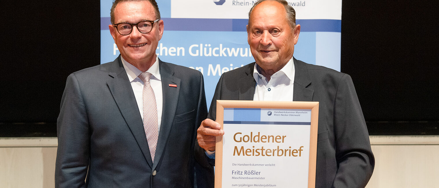  Kammerpr&auml;sident Klaus Hofmann &uuml;berreicht Maschinenbauermeister Fritz R&ouml;&szlig;ler auf der Goldene Meisterfeier in Wiesloch 2022 seinen Goldenen Meisterbrief