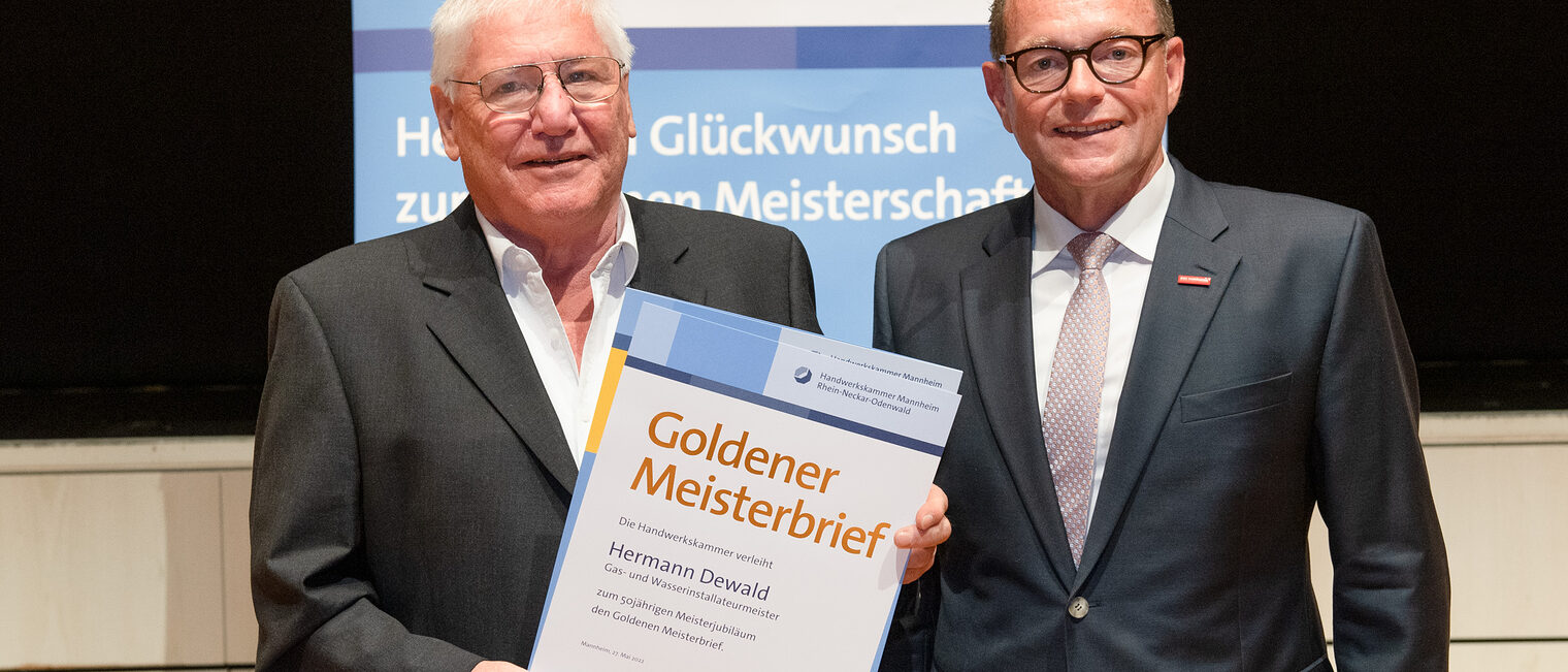 Kammerpräsident Klaus Hofmann überreicht Gas- und Wasserinstallateurmeister Hermann Dewald auf der Goldene Meisterfeier in Wiesloch 2022 den Goldenen Meisterbrief