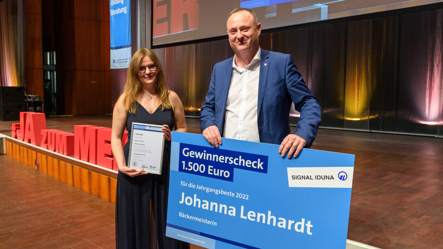 Axel Bauer (rechts). Bäckermeisterin Johanna Lenhardt links hält einen Scheck in den Händen.