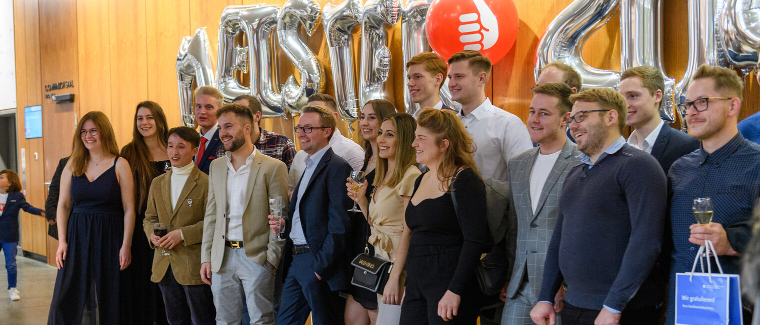 Gruppenbild der B&auml;ckermeister auf der Meisterfeier 2022 mit dem Schriftzug "Meister 2022" aus Luftballons im Hintergrund.