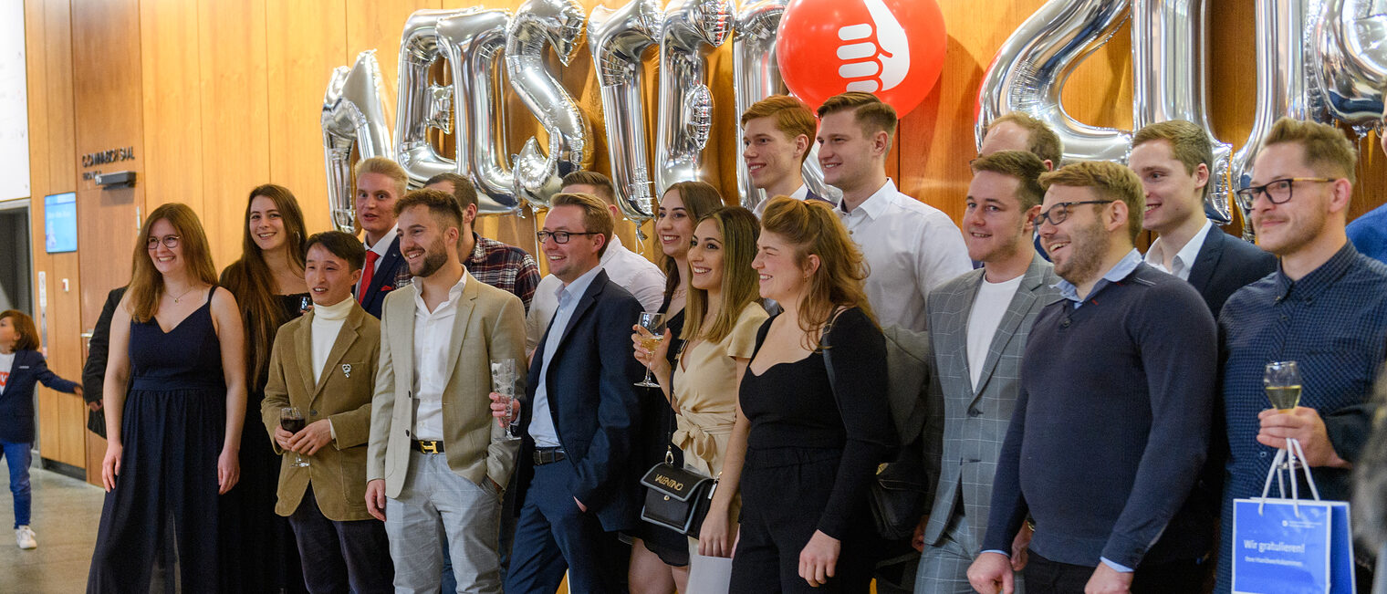 Gruppenbild der Bäckermeister auf der Meisterfeier 2022 mit dem Schriftzug "Meister 2022" aus Luftballons im Hintergrund.