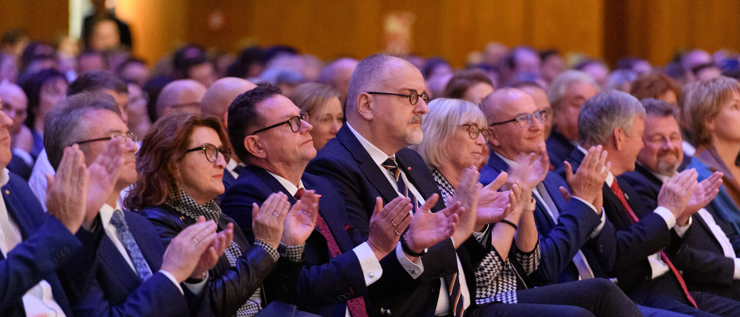 Das Bild zeigt die klatschenden Ehrengäste der ersten Reihe auf der Meisterfeier 2022. 