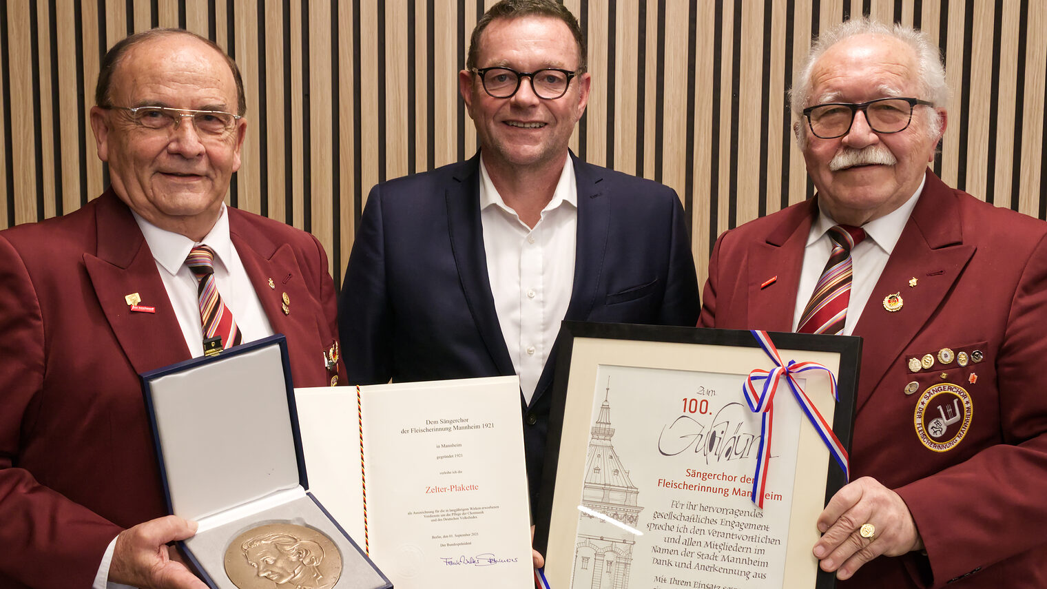 Berthold Bissinger, Präsident des Deutschen Fleischersängerbundes links stehend, Klaus Hofmann, Präsident der Handwerkskammer in der Mitte stehend und Karl Wowy, erster Vorsitzender des Sängerchors rechts stehend. 