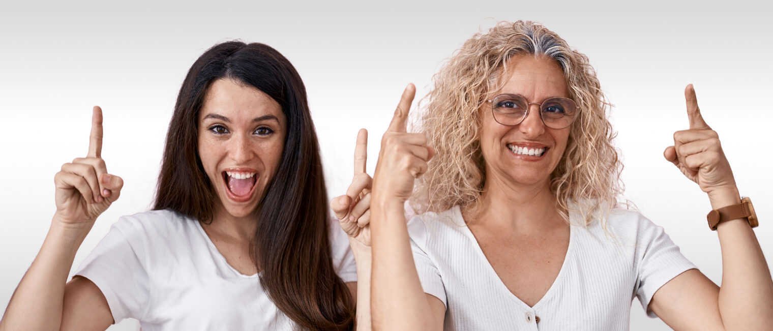 Tag der Ausbildung für Eltern und Kinder Zwei Frauen zeigen mit ihren Zeigefingern nach oben und schauen freudig.