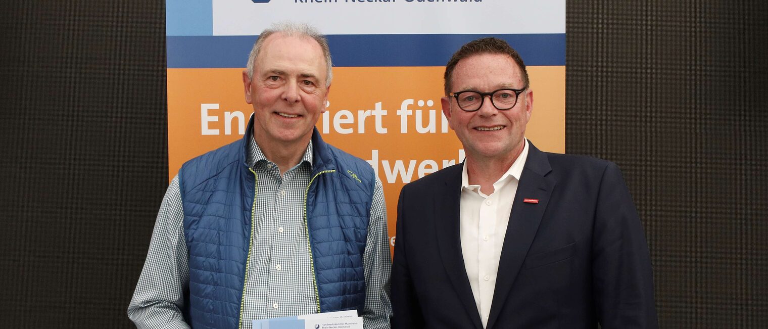 Theo Herrmann mit seiner Ehrenurkunde f&uuml;r langj&auml;hriges Engagement im Meisterpr&uuml;fungswesen und Kammerpr&auml;sident Klaus Hofmann.