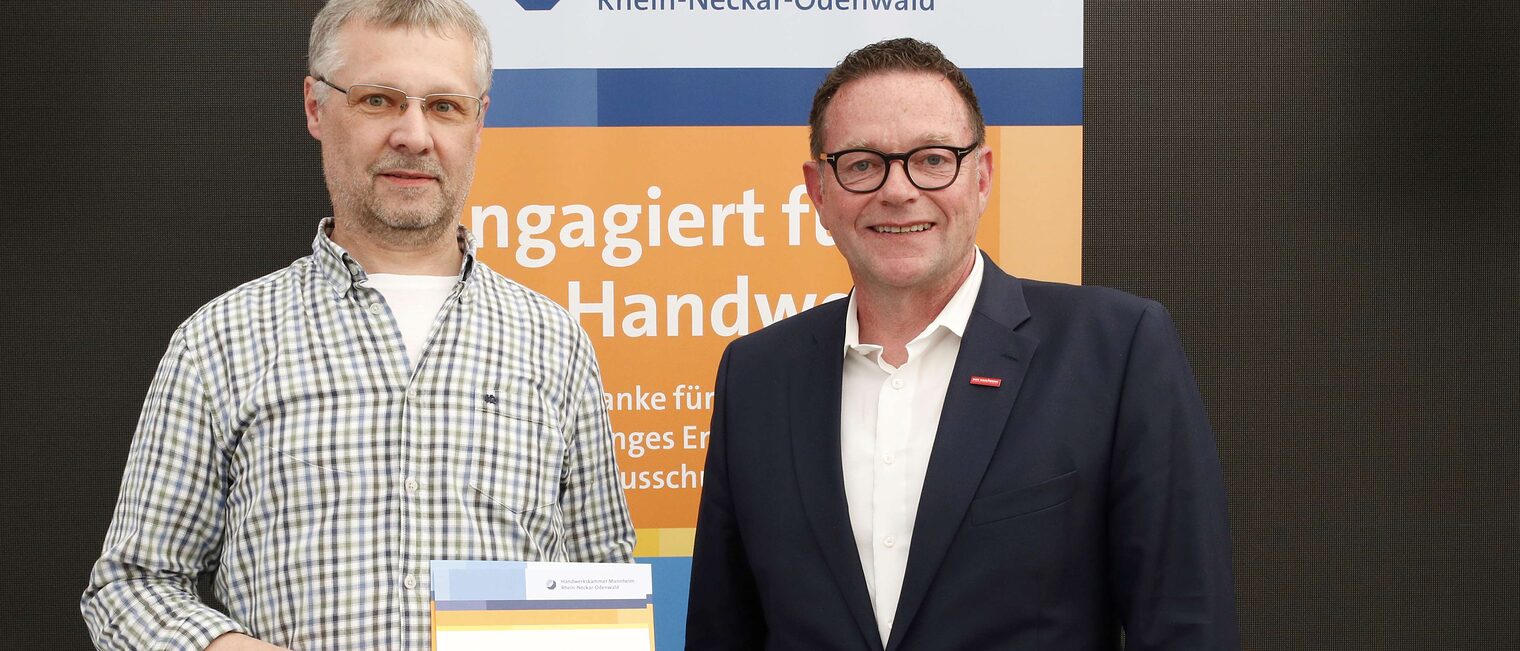 Wolfgang Keller mit seiner Ehrenurkunde f&uuml;r langj&auml;hriges Engagement im Meisterpr&uuml;fungswesen und Kammerpr&auml;sident Klaus Hofmann.