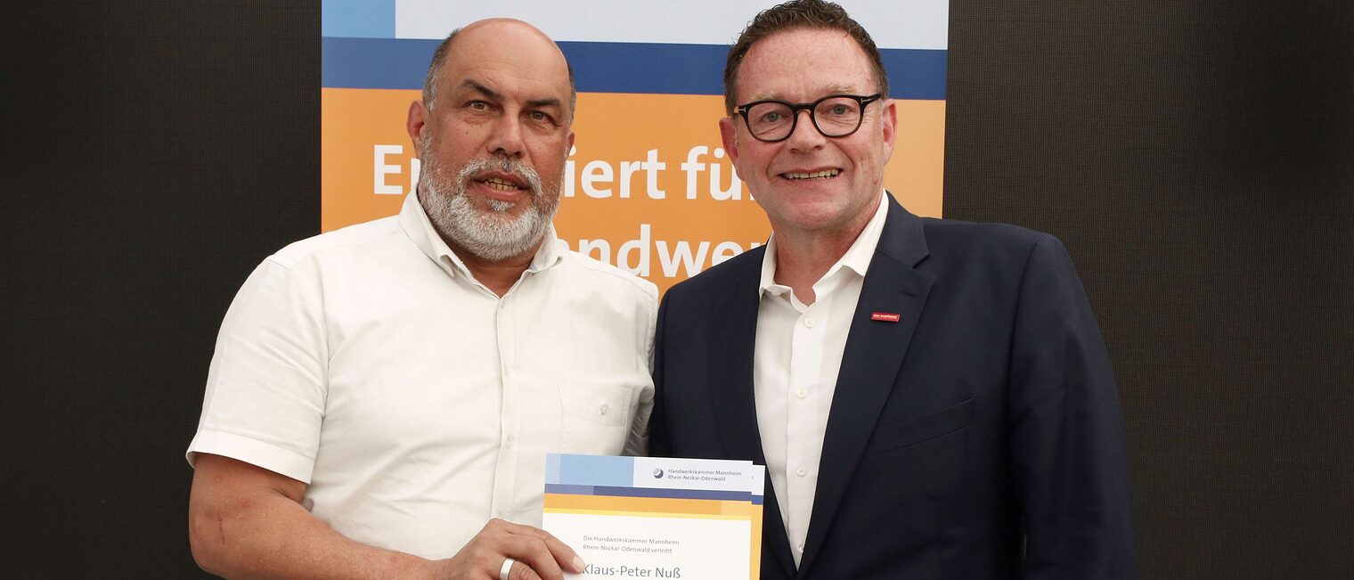 Klaus-Peter Nuß mit seiner Ehrenurkunde für langjähriges Engagement im Meisterprüfungswesen und Kammerpräsident Klaus Hofmann.