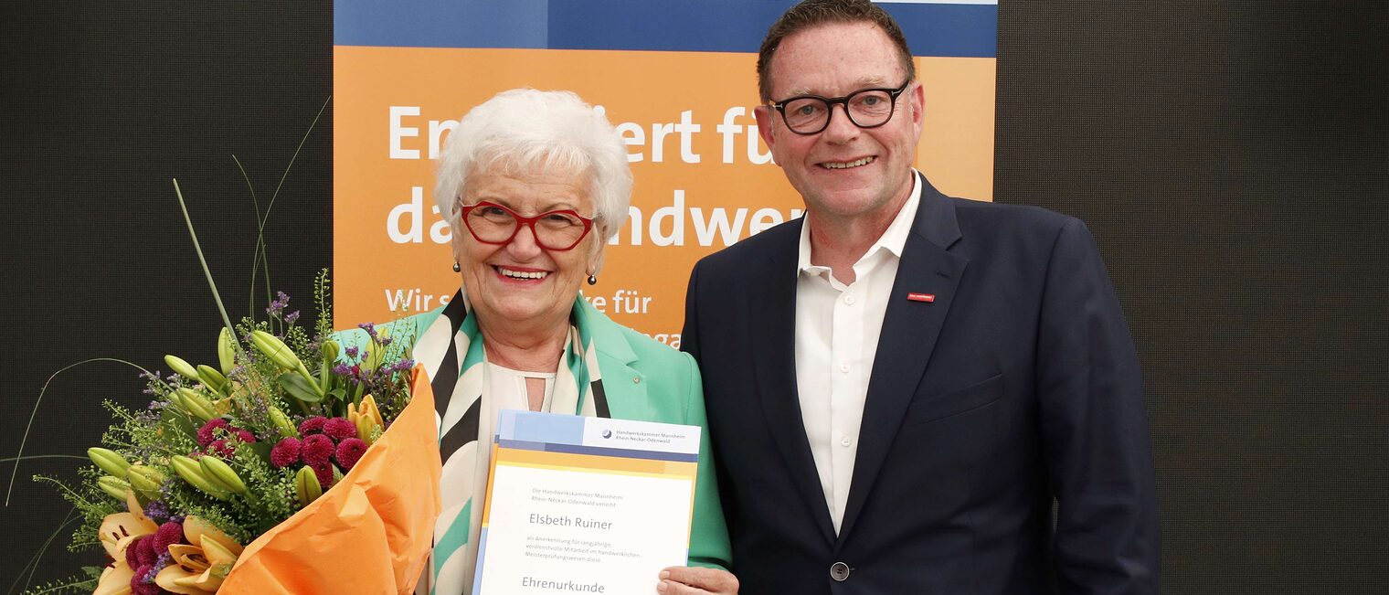 Elsbeth Ruiner mit ihrer Ehrenurkunde für langjähriges Engagement im Meisterprüfungswesen und Kammerpräsident Klaus Hofmann.