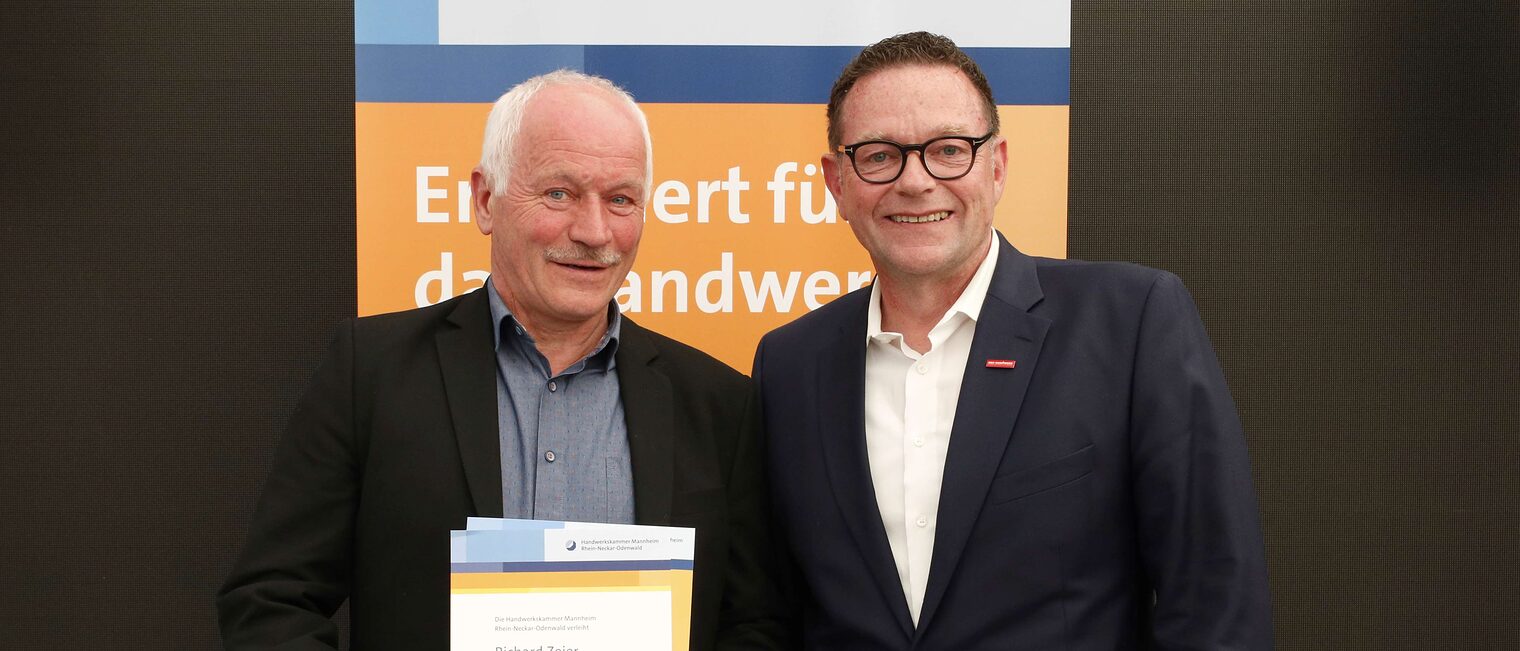 Richard Zeier mit seiner Ehrenurkunde f&uuml;r langj&auml;hriges Engagement im Meisterpr&uuml;fungswesen und Kammerpr&auml;sident Klaus Hofmann.